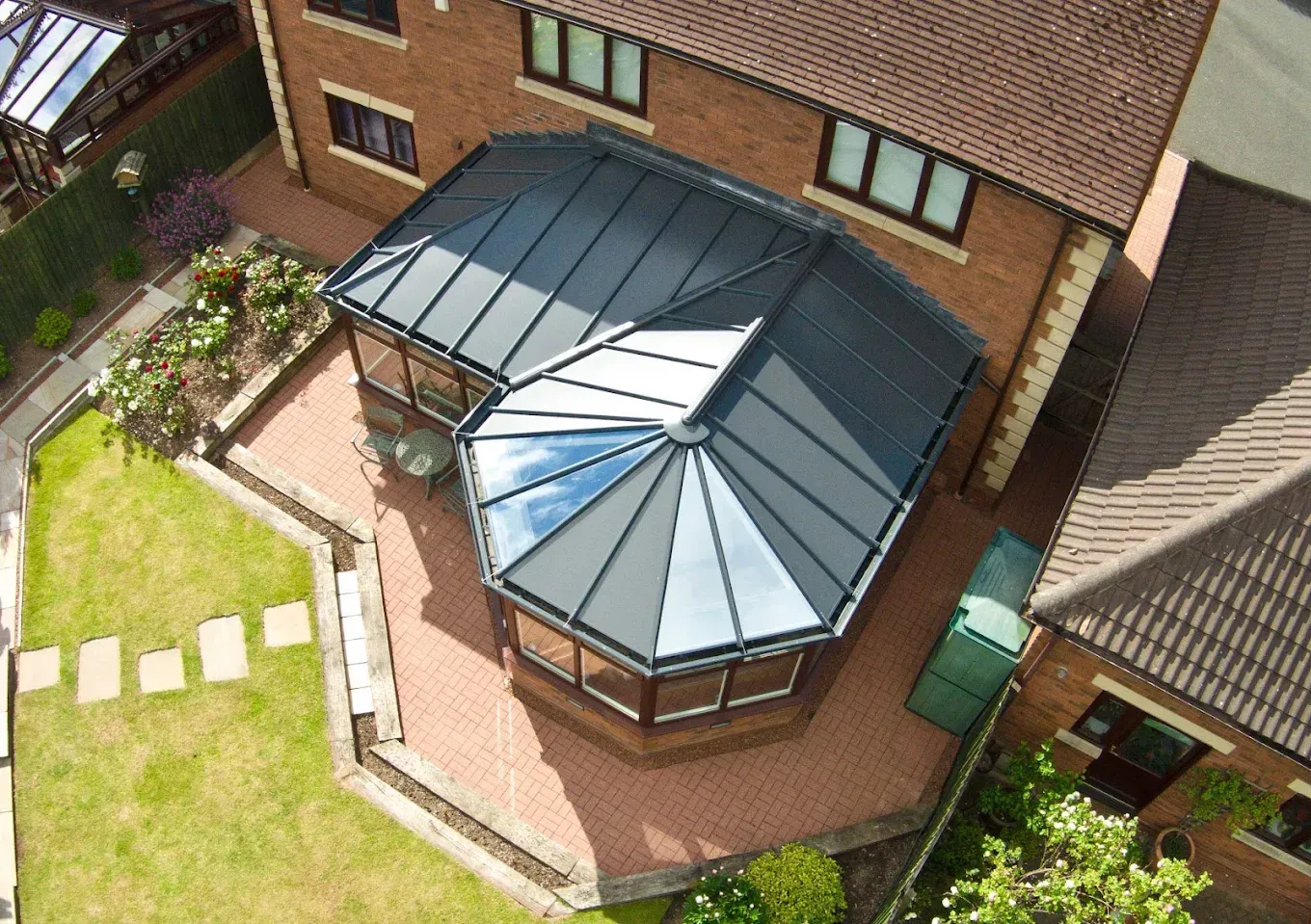 Aerial view of a transformed conservatory with a dark grey hybrid tiled and glass warm roof