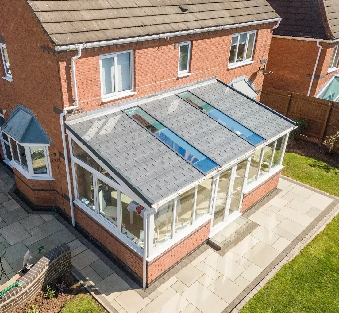 House with a new tiled conservatory roof and rooflights, showing a completed installation.