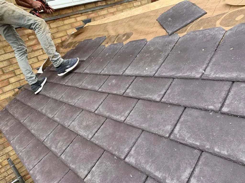 Installing grey tiles on a warm conservatory roof conversion.
